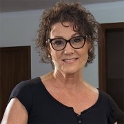 Woman with curly, dark hair and glasses